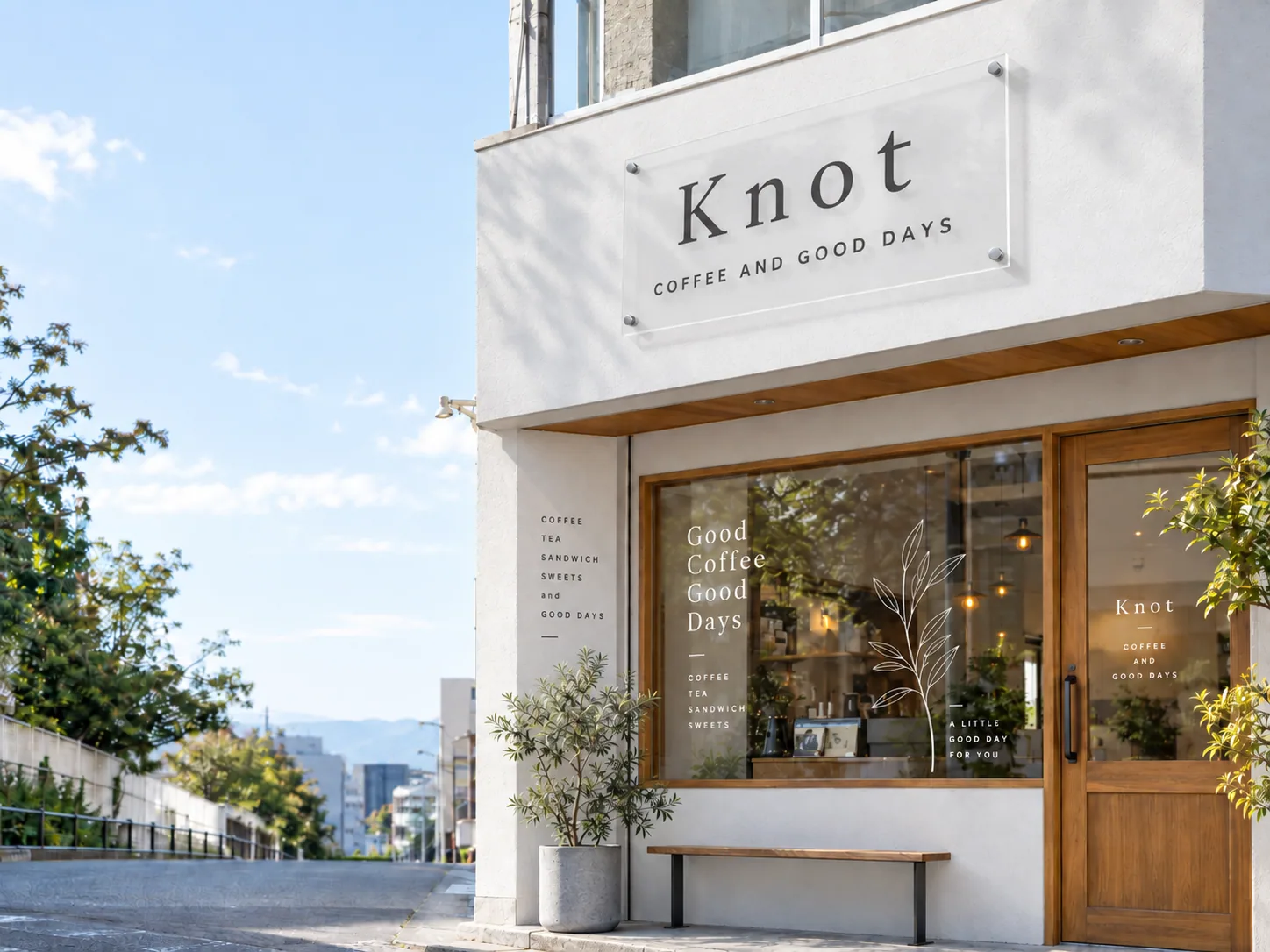 白い外壁に透明な店舗看板を取り付けたカフェ「Knot」の外観イメージ